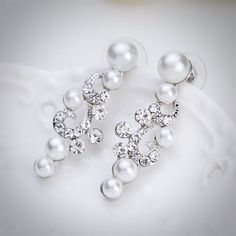 A classy bridal necklace and earrings set, perfect for the romantic bride! Adorned with iridescent pearls and clear crystals that capture the light from every angle sparkling beautifully, the pieces are rhodium plated for a flawless finish which enhances the intricate detailing and conveys a modern take on old elegance. Necklace: 16" long (approx. 41cm) with a 2.5" extension chain (approx. 6.5cm) which allows the length to be adjusted to 18.5" (approx. 47.5cm). If you would like it longer, pleas Formal White Crystal Pearl Earrings, White Crystal Pearl Earrings For Formal Occasions, Formal Silver Pearl Jewelry Sets, Elegant Crystal Jewelry Sets With Pearl Drop, Silver Pearl Embellished Jewelry Sets For Wedding, Elegant White Crystal Jewelry Sets, Elegant Silver Pearl Jewelry Sets, White Pearl Earrings With Sparkling Stones, Silver Bridal Necklace With Pearl Drop And Cubic Zirconia