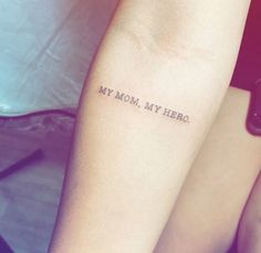 a woman's arm with the words my mom, my hero tattooed on it