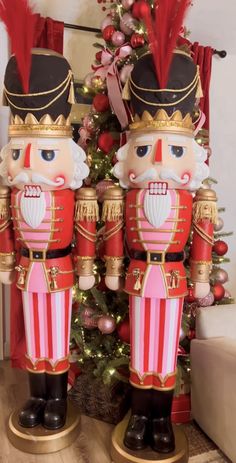 two nutcrackers are standing next to a christmas tree