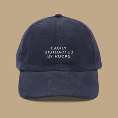 Let your hat reveal your true passion for rocks, because who can resist a good rock when they see one? Elevate your style with this embroidered vintage cap that proudly proclaims your love for the earth's treasures. Crafted meticulously from premium 100% cotton corduroy, this cap ensures a gentle feel against your skin, just like the smooth surface of your favorite rock. Its timeless design features an adjustable strap with a gold-colored buckle, guaranteeing a fit so perfect that not even the a Easily Distracted By Rocks, Funny Baseball Hat, Vintage Hats For Women, Vintage Baseball Hats, Embroider Ideas, Embroidered Corduroy, Rock Hat, Corduroy Hat, Baseball Humor