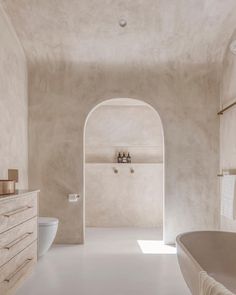 a bathroom with a large white bathtub next to a toilet