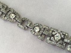 "Absolutely beautiful 1920's style \"Flapper\" bracelet. Studded with clear, sparkling, paste rhinestones on silver tone pot metal backing. This romantic stunner has a jeweled fold over clasp. I think this was made in the '20's or '30's. This particular Art Deco style was popular for many years. Larger stones are prong set. Very nice antique condition. Length: 7 1/2\" 5/8\" W (at widest) Attention: All items are listed to the best of our observation, but they are pre-owned and pre-loved (meaning Art Deco Platinum Silver Tennis Bracelet, Art Deco Diamond Bracelet With Accents, Art Deco Silver Diamond Bracelet, Art Deco Silver Diamond Bracelets, Art Deco Diamond Bracelet In Silver, Vintage Silver Diamond Bracelet In Platinum, Vintage Platinum Diamond Bracelet, Vintage Cubic Zirconia Bracelets With Diamond Accents, Art Deco Silver Bracelets With Diamond Accents