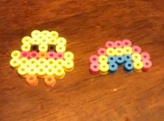 two pieces of plastic beads sitting on top of a wooden table next to each other