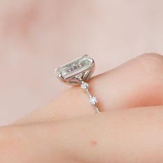 a woman's hand with a diamond ring on it