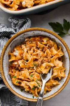 two bowls filled with pasta and meat covered in sauce