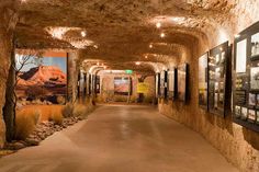 a long hallway with pictures on the walls and posters hanging from the ceiling in front of it