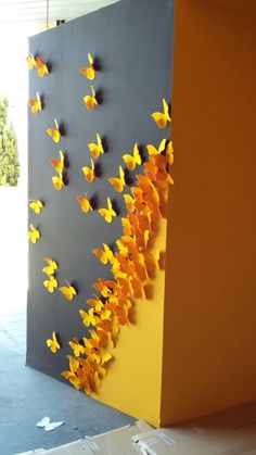 yellow butterflies are on the side of a gray and yellow wall in front of a doorway