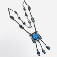 Gorgeous Vintage/Antique Art Deco Faux Star Sapphire Glass & Blue Rhinestone Necklace. Ornate silver gilt metal set with large faux star sapphire glass cabochon and accented with blue rhinestones and ornate dangles. In excellent vintage condition with minimal age appropriate wear. No chips or cracks. Any white area seen on glass cabochon is only a glare. The glass cabochon is perfect. Pendant including dangles measures 2 1/2 inches long by 1 inch wide. The chain is ornate scrolling silver gilt metal links and some set with blue rhinestones. Total length is 19 1/2 inches long. Clasp secure Ornate Blue Nickel-free Jewelry, Ornate Nickel-free Blue Jewelry, Antique Blue Metal Jewelry, Vintage Blue Cabochon Jewelry, Blue Art Deco Jewelry For Jewelry Making, Blue Vintage Cabochon Jewelry, Antique Blue Cabochon Necklace, Antique Nickel-free Blue Jewelry, Antique Blue Nickel-free Jewelry