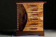 a wooden cabinet with drawers on it in front of a black background and blue light