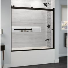 the shower door is open to reveal a white and black bathroom