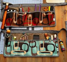 two purses with sewing supplies in them on a table