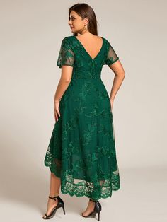 a woman is wearing a green dress with sheer sleeves and lace detailing on the shoulders