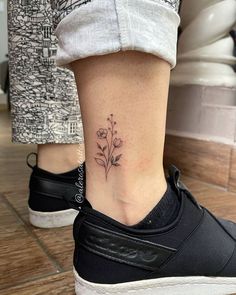 a small flower tattoo on the ankle