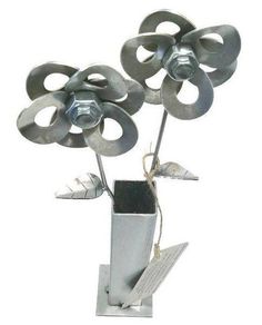 a metal vase with three flowers in it