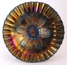 a glass plate with a flower in the center on a white surface, it appears to be an art object