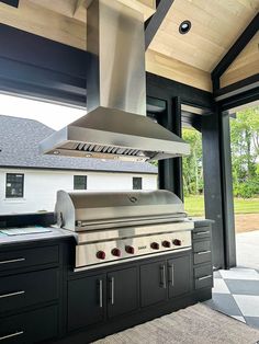 an outdoor kitchen with stainless steel appliances and large sliding glass doors