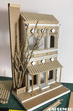 a paper model of a house with trees in the front and on the back side