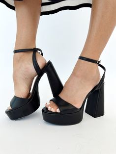 Elevate your style with our Black Open Toe Platform Heel. This elegant heel features a platform and block heel for elevated comfort, perfect for formal occasions like dinner, drinks, or date night. The open toe and strappy details add a touch of sophistication, making it a must-have for any fashion-forward individual. Heel height: 5" Trendy Platform Sandals For Formal Occasions, Chic Platform Heels With Block Heel, Elegant Synthetic Platform Block Heels, Glamorous Chunky Platform Heels In Synthetic Material, Modern Party Heels Medium Width, Modern Medium Width Heels For Party, Modern Medium Width Party Heels, Platform Block Heels With Medium Width, Platform Heels With Block Heel And Medium Width