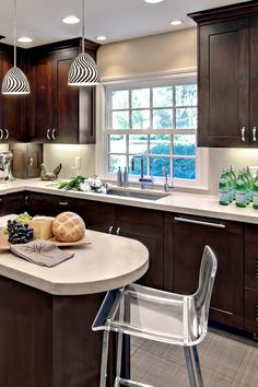 a kitchen with brown cabinets and white counter tops, an island in the middle has fruit on it