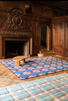 a blue and red rug in front of a fireplace