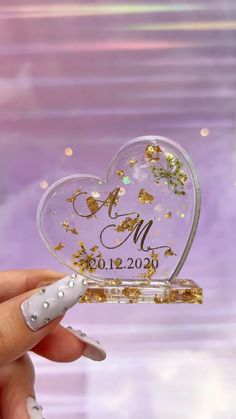 a heart shaped glass ornament with gold glitters