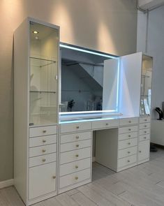 an empty dressing room with white drawers and lights