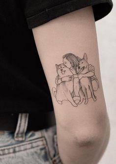 a person with a tattoo on their arm holding a cat and hugging it's back