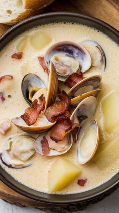 clams and bacon soup in a bowl with bread on the side