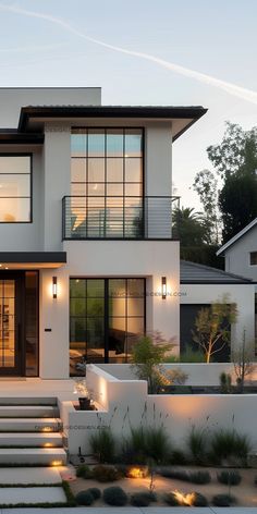 a modern house with steps leading to the front door and stairs up to the second floor