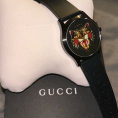 Gucci Watch Brand New Never Used Comes With The Box The Pillow And The Book On The Numbers On The Back Of The Watch I Posted In The Pictures Authentic Gucci, Watch Black Tiger Face No Numbers Gucci On The Strap Gucci Black Luxury Watch, Gucci Timeless Black Watch, Black Gucci Timeless Watch, Designer Black Gucci Watch, Modern Black Gucci Watch, Gucci Luxury Watch With Round Dial, Gucci Luxury Watch Accessories With Round Dial, Luxury Gucci Watch Accessories With Diamond Hour Markers, Designer Gucci Watch For Evening