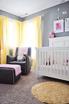 a baby's room with yellow drapes and gray carpet