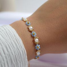 Handmade Daisy Chain Bracelet with 14kt Gold Plated Findings. Handmade Friendship Bracelet. Handmade Beaded Flower Bracelet. Beaded Flower Bracelet.  Love Daisy - Elsa Blossom Bracelet  - Handmade beaded daisy bracelet in blue - 14k gold-plated stainless steel extension chain, lobster clasp, and crimp - Glass miyuki seed beads and high-quality nylon string for durability Features: - 2mm blue Miyuki beads for daisies - 2mm 14k gold-filled beads - 4mm cloudy round rondelle crystals - 15/0 14k gold-filled beads - Adjustable length: 15cm (up to 21.5cm with extension chain) - Custom sizes available upon request - Free accessories with every order: box, bracelet pouch, bookmark, and handmade bracelet helper tool - Care tip: Minimize contact with water to prevent bead colour fading. Glass Bead Patterns, Beaded Daisy Bracelet, Daisy Chain Bracelet, Beaded Flower Bracelet, Steel Extension, Beaded Daisy, Blossom Bracelet, Handmade Friendship Bracelets, Diy Jewelry Unique