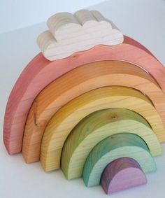 a rainbow shaped wooden toy sitting on top of a white table