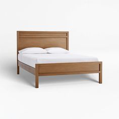 a wooden bed frame with white sheets and pillows on the headboard, in front of a plain background