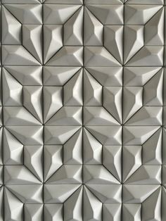 an abstract wall made up of many different shapes and sizes, all in grey tones