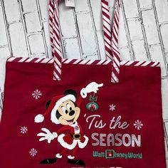 Disney Park Tote Bag Holiday Mickey Mouse Tis The Season In Red With Candy Cane Stripes. From Walt Disney World Perfect Canvas Bag For The Holidays, Carry All Gifts In This Beautiful Tote Bag. A Collectors Item! And A One Of A Kind! Disney Reusable Shopping Tote Bag, Featuring Mickey Mouse Celebrating The Holidays, Surface Wash Only. Imported Thank You For Looking Disney World Halloween, Disney Tote Bags, Disney Tote, Holiday Tote Bag, Mickey Silhouette, Disney World Christmas, Disney 50th Anniversary, Disney Bags, Christmas Tote Bags