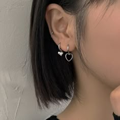 a close up of a person wearing some kind of earring with hearts on it