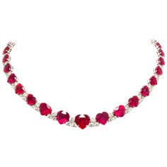 The heart shape ruby and diamond necklace is constituted by 34 faceted rubies of homogeneously brilliant quality, especially cut from larger Mozambique rough to obtain the regular and symmetrical graduation from center to back. The total weight of rubies after cutting is approximately 95 carats. The colored stones are interspersed with diamond motifs set with a total of 7.78 carats of round diamonds of top quality (F/VVS). The neckpiece is one-of-a-kind not only for the difficult matching/cuttin Ruby Diamond Necklace Set, Red Ruby Necklace, Riviera Necklace, Ruby Bracelets, Heart Diamond Necklace, Ruby Heart Necklace, Heart Shaped Diamond Necklace, Ruby Necklace Designs, Ruby Diamond Necklace