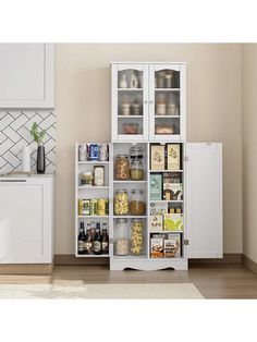 a kitchen with white cabinets and shelves filled with various items on the floor, in front of a beige wall