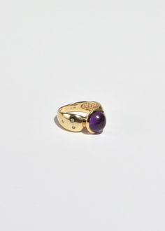 Stunning vintage gold ring with round amethyst cabochon and petite sapphire detail. Stamped 10k. Material: 10k gold, amethyst, sapphire. We recommend storing in a dry place and periodic polishing with a cloth. Heirloom Amethyst Rings With Gemstone Accents, Timeless Yellow Gold Amethyst Ring, 14k Gold Cabochon Sapphire Ring, Formal Amethyst Birthstone Ring With Round Stone, Timeless Round Amethyst Ring, Classic Amethyst Oval Cabochon Ring, Gold Amethyst Oval Cabochon Ring, Yellow Gold Amethyst Cabochon Ring, Yellow Gold Amethyst Ring With Gemstone Accents