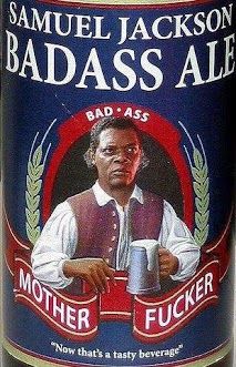 a close up of a bottle of beer with a man holding a cup in his hand