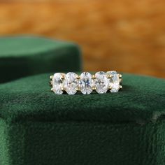 three stone diamond ring sitting on green velvet