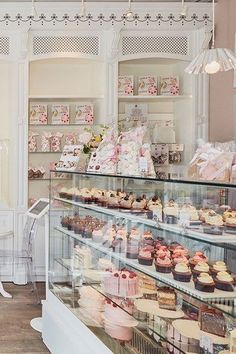 a bakery filled with lots of different types of cakes and cupcakes on display