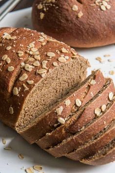 two loaves of bread sitting on top of a white plate next to a loaf of bread