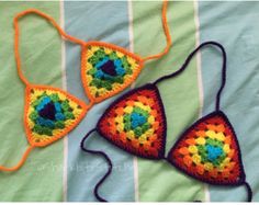 two crocheted bikinisuits are laying on a striped bed sheet, one has an eyeball in the middle