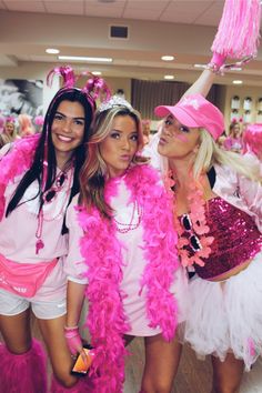 three women dressed in pink and white posing for the camera