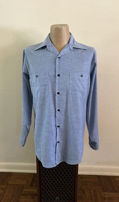 For your consideration Original vintage 1970s Sears Perma Prest Chambray Work Shirt Long sleeve Cotton blend Made in USA Marked size Tall Large 16 - 16 1/2 Two button through pockets Single button cuffs Long tail Button front In pre-owned condition .. looks hardly worn .. tag is crispy .. don't see any holes or tears .. does have two faint yellowing spots on left chest pocket Shown on men's vintage size medium mannequin torso Measures approximately 23.5" pit to pit 31.75" top neckline to bottom 19" across shoulders 25.75" sleeves 17.5" pit to bottom Zoom in on photos for details and overall condition and message with any questions Mannequin Torso, Top Neckline, Cowboy Rodeo, Work Shirt, Long Tail, Mens Oxfords, Work Shirts, Long Sleeve Casual, Vintage 1970s