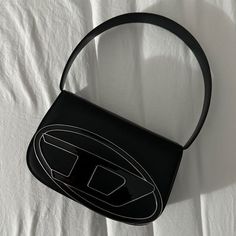 Elevate your style with our Diesel Y2K Bag. This versatile tote handbag comes in black and silver, offering a chic and timeless aesthetic with a touch of grunge. Cute Handbag Outfit, Cute Bags Designer, Black Diesel Bag, Cute Purses Black, Black Handbag Aesthetic, Trend Bag 2024, Diesel Bag Aesthetic, Aesthetic Purses And Bags, Aesthetic Bags Handbags