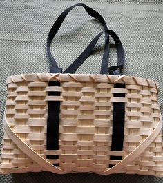 a woven bag sitting on top of a bed