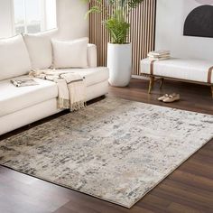 a living room with a white couch and rug on the floor in front of a window